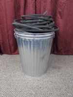 THIRTY GALLON TRASH CAN FULL OF SOAKER HOSE.